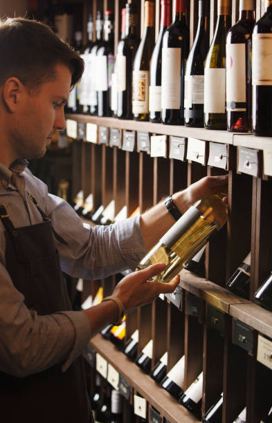 istock Thoughtful expert in winemaking on background of shelves with wine. 1376240757