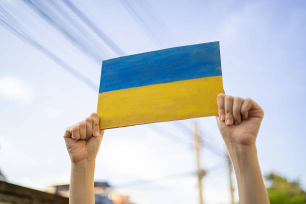 A man holding cardboard painted into Ukraine flag A man holding cardboard painted into Ukraine flag ukrainian language stock pictures, royalty-free photos & images