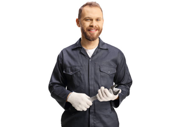 istock Smiling young mechanic in a uniform holding a wrench tool 1376280583