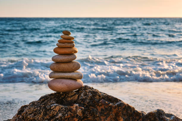 concept of balance and harmony - stone stack on the beach - cairn stacking stone rock imagens e fotografias de stock