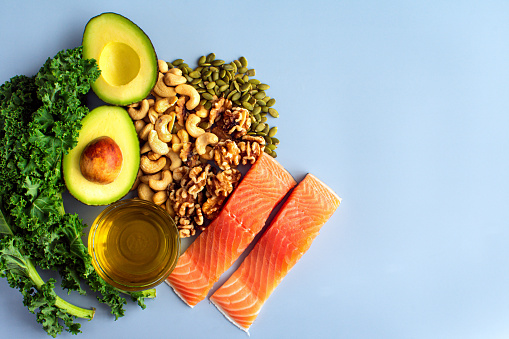 A variety of healthy foods like fish, nuts, seeds, fruit, vegetables, and oil rich in omega-3 nutrients