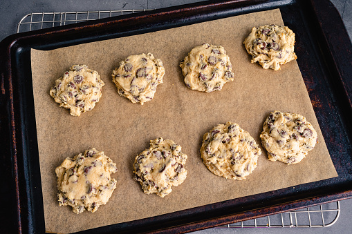 Chocolate chip cookies on a sheet pan lined with parchment paper