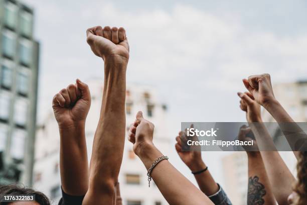 People With Raised Fists At A Demonstration In The City Stock Photo - Download Image Now