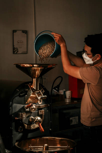 A young asian coffee roaster is using a professional roaster to roast coffeeSpecialty CoffeeCoffee MachineCoffee Roastery