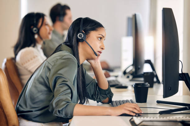 istock Shot of a young call centre agent looking bored while working on a computer in an office 1376355650