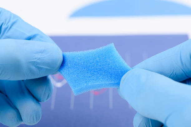 Blue porous foam material stretched in scientist hands in laboratory. Research for material with new properties concept.