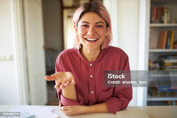 Happy Cute Teenage Girl With Pinkish Hair Smiling Broadly While Talking To Friend Online Using Video Conference Service Stylish Young Female Influencer Recording Vlog Via Webcam On Electronic Device Stock Photo - Download Image Now