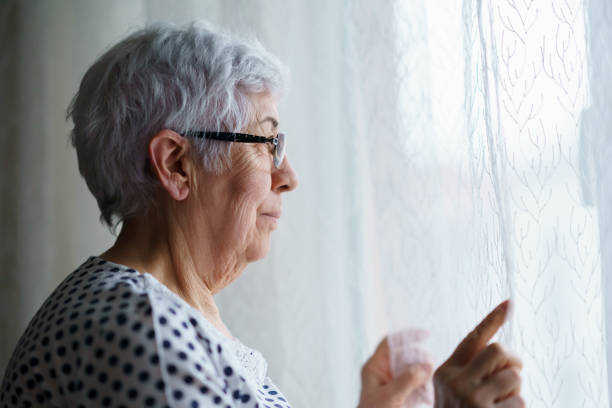 istock Senior Woman standing in front of a window 1376405085