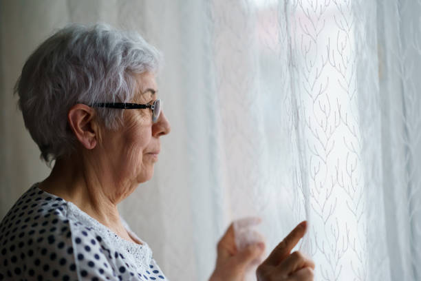istock Senior Woman standing in front of a window 1376405146