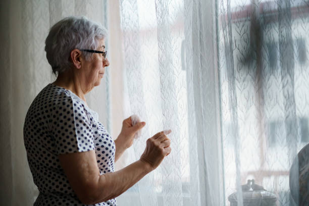 istock Senior Woman standing in front of a window 1376405158