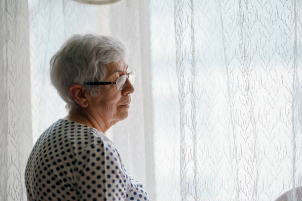 istock Senior Woman standing in front of a window 1376405234