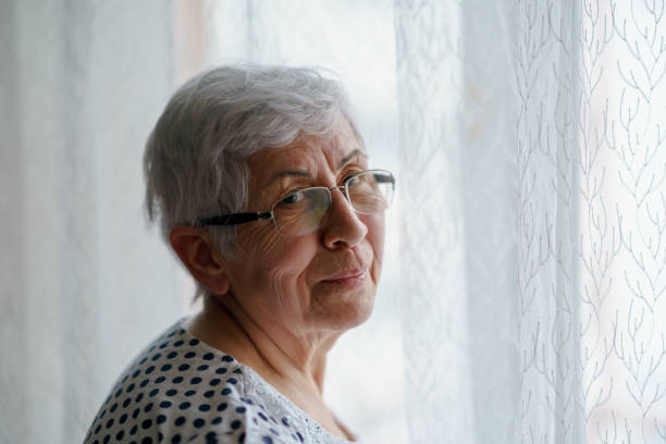 istock Senior Woman standing in front of a window 1376405287