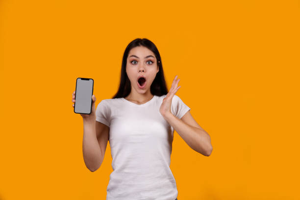 istock Young woman with a phone on yellow background. 1376441689