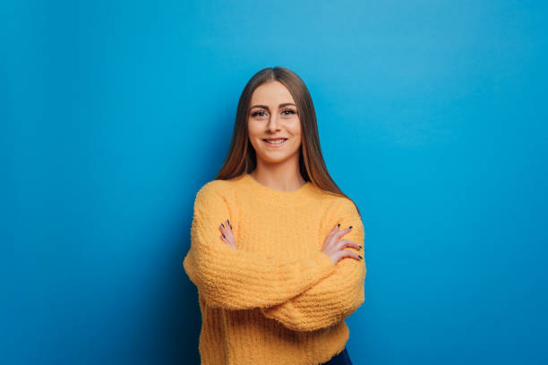 istock Woman looking at camera and smiling while posing with arms crossed on isolated background. 1376444238