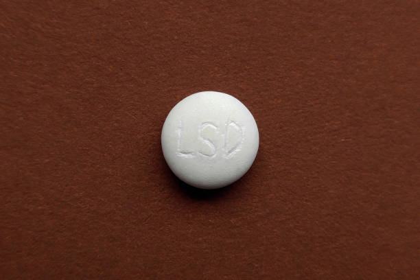 LSD tablet on brown background stock photo