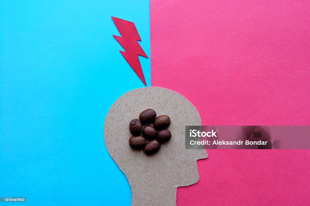 Caffeine overdose. A caffeinated blow to the head. The head of a man with coffee beans inside. The image is made of cardboard. Lightning Stock Photo