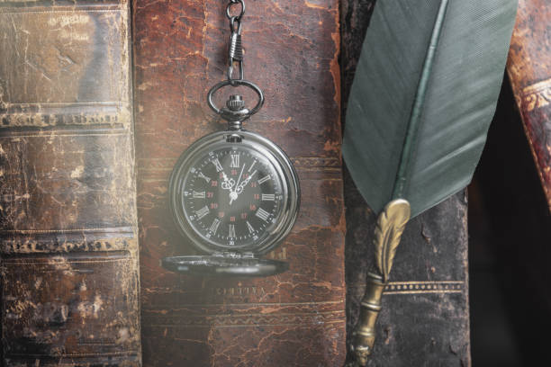 istock Classic still life with vintage books placed with old clock on rustic wooden background. 1376490468