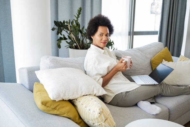 istock Woman relaxing on the couch and using laptop 1376495716