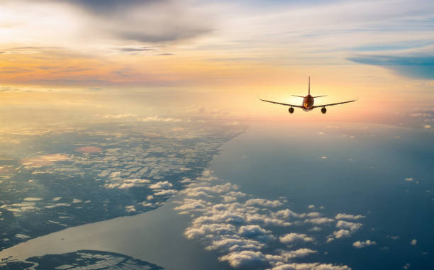 Airplane flying over tropical sea atduring sunset,copy space for text.