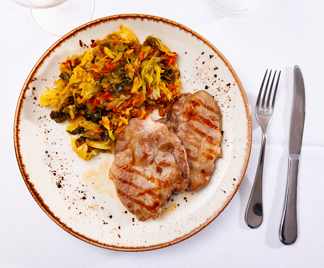 German dish, grilled pork chop garnished with stewed cabbage in a restaurant