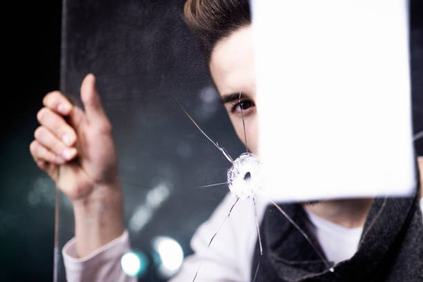 istock Young man holding blown and cracked glass. 1376517589