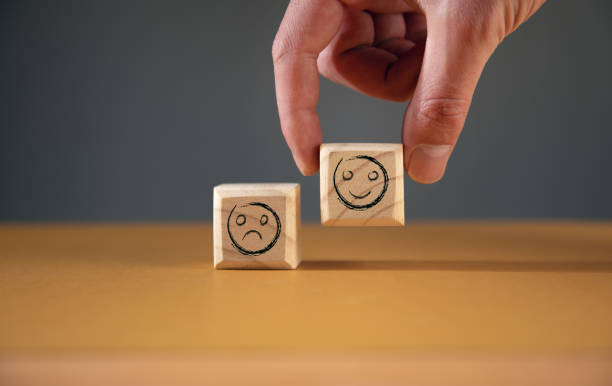 istock Hand holding smile face symbol on wooden cube 1376521521