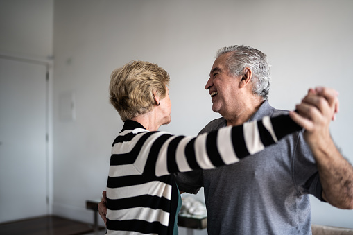 Senior couple waltzing at home