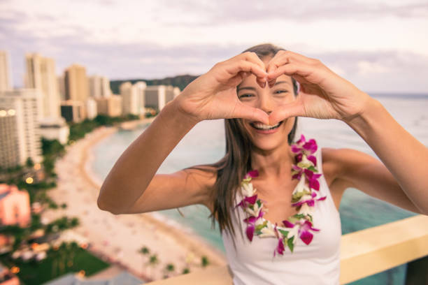 glücklicher hawaii waikiki strandtourist macht herzform mit händen genießen honolulu stadtreise urlaub in luxus resort balkon blick auf den sonnenuntergang. - hawaii islands luau hula dancing hawaiian culture stock-fotos und bilder