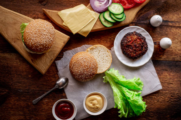 istock Hamburger day. Cooking hamburger or cheeseburger. Different ingredients for a classic hamburger. Place for text. Wooden background. 1376528123