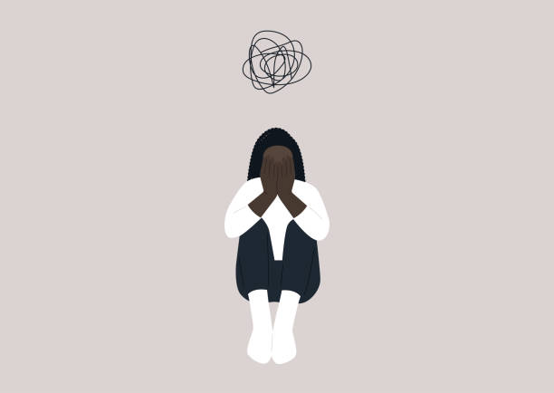 istock A young female African character covering their face with hands, a desperate situation, racism, stress and anxiety, mental health issues 1376529395