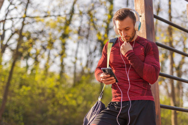 Man using smart phone after outdoor workout stock photo
