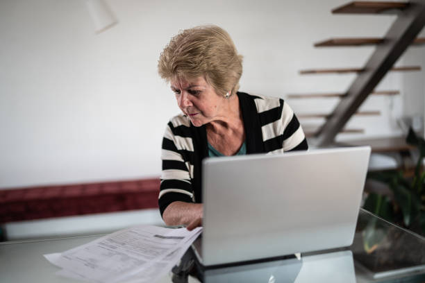 istock Focused senior woman using laptop at home 1376529822