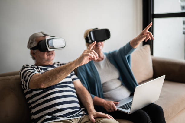 istock Senior couple playing with VR glasses at home 1376529859
