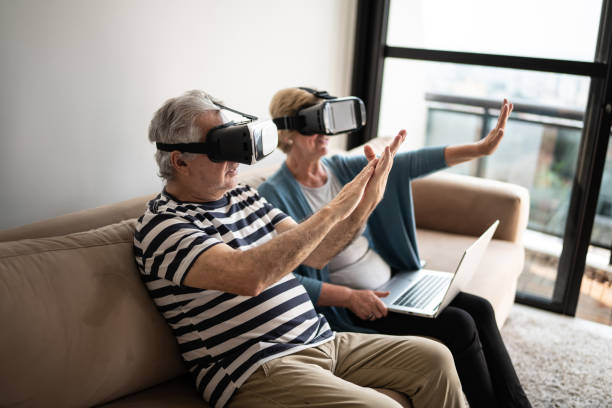 istock Senior couple playing with VR glasses at home 1376529873