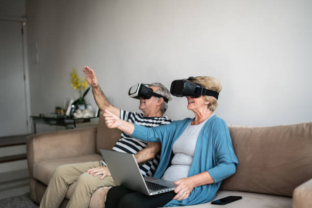 istock Senior couple playing with VR glasses at home 1376529875