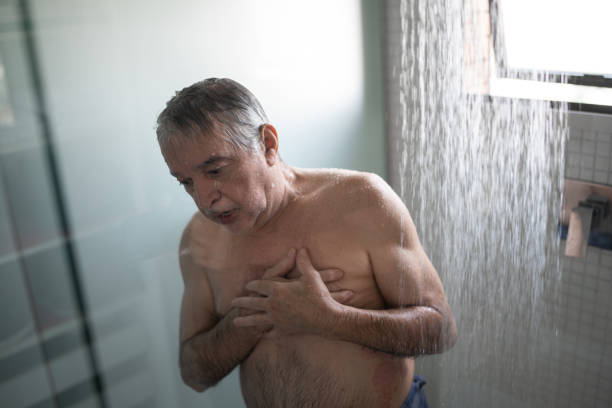 샤워를하는 동안 가슴 통증을 느끼는 노인 - men naked shower bathroom 뉴스 사진 이미지