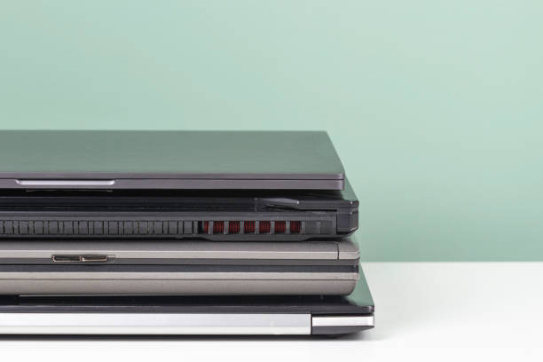 istock Pile of old used laptop computers for recycling on white table. Planned obsolescence, e-waste, electronic waste for reuse and recycle concept 1376539879