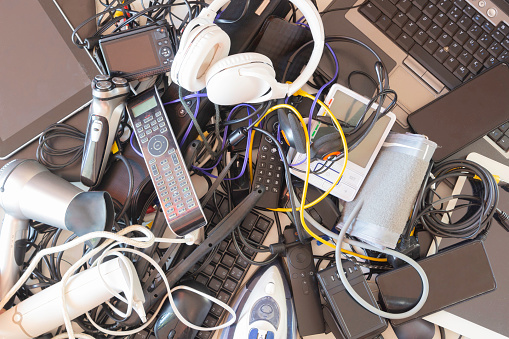 Top view to old computers, digital tablets, mobile phones, many used electronic gadgets devices, broken household and appliances. Planned obsolescence, electronic waste for recycling concept.