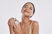istock Studio shot of a young woman spraying herself with perfume 1376552130