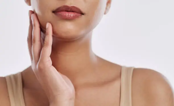 Photo of Closeup shot of a young woman touching her face