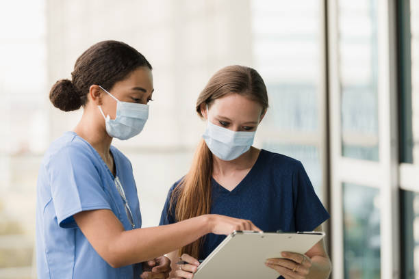 istock Female surgeons wear masks to prevent illness while discussing chart 1376575383