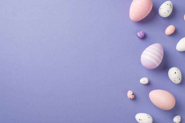 istock Top view of a few multicolored Easter eggs different size with stripes and dots on the pastel purple isolated background copyspace 1376601540