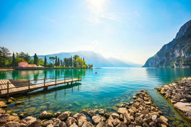 jetée en bois sur le lac. riva del garda, italie - northern lake photos et images de collection