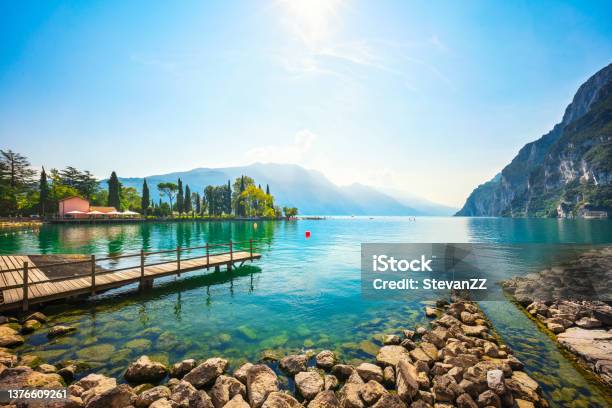 Wooden Pier On The Lake Riva Del Garda Italy Stock Photo - Download Image Now - Lake Garda, Lake, Riva del Garda