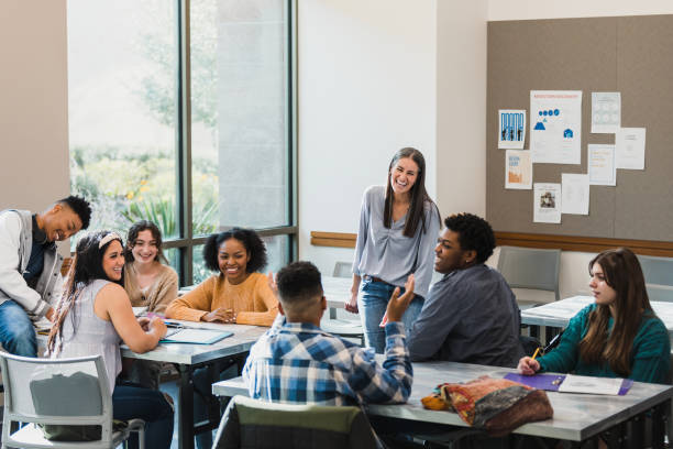 istock Classmates and teacher smile and laugh when boy makes joke 1376611823