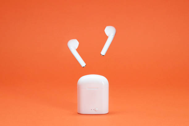 istock Wireless headphones on the orange background 1376623684