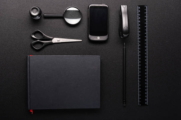 Stationery in black color on a black table. Neatly folded items. Flar lay. View from above.