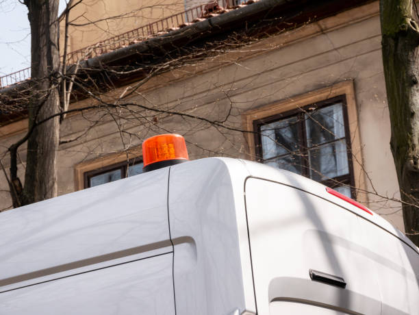 Generic emergency service vehicle van with an orange emergency light on top, flashing beacon siren signal on a car roof, object closeup, detail, nobody. Urban construction, cleaning services concept