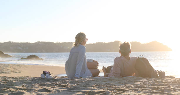 istock Mature couple relax on sandy beach, at sunrise 1376652168