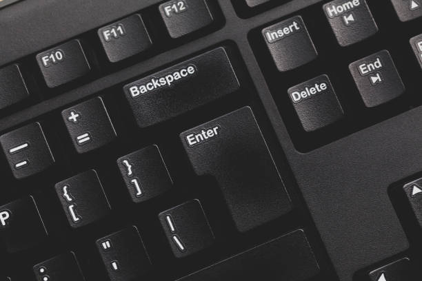 istock Simple modern black dark grey matte computer keyboard keys detail, background top view, enter key from above, nobody. Desktop PC keyboard minimal modern abstract shot, office equipment, business 1376657850